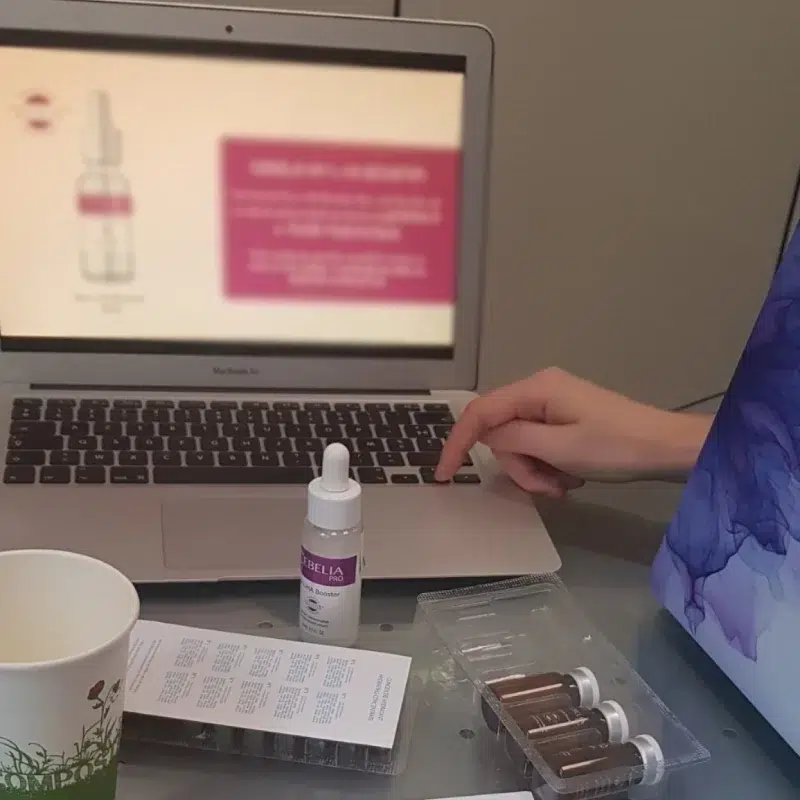 Personne utilisant un ordinateur avec des produits cosmétiques